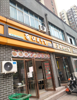 店铺两侧是学校，后面是小区，前面是化I大市场